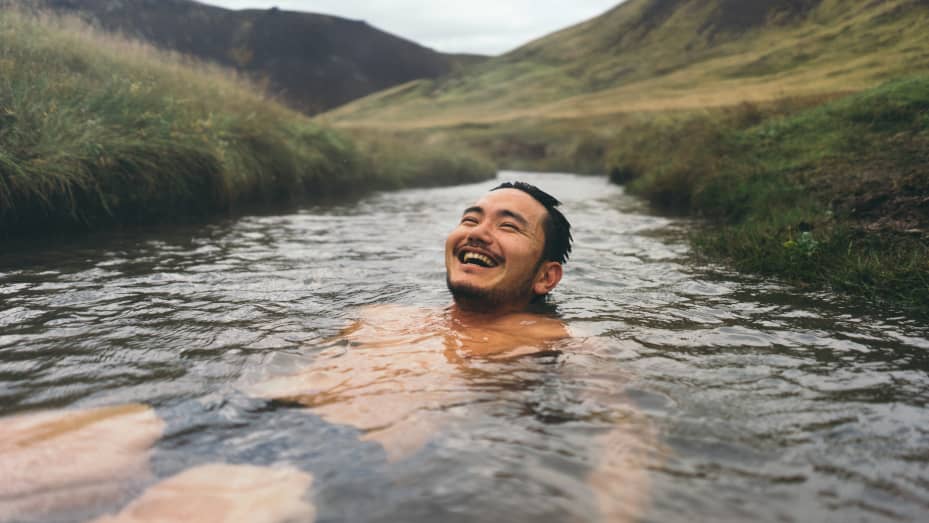 A man soaks in a natural hot spring in Iceland.