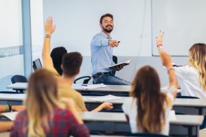 High school students raising hands on a class