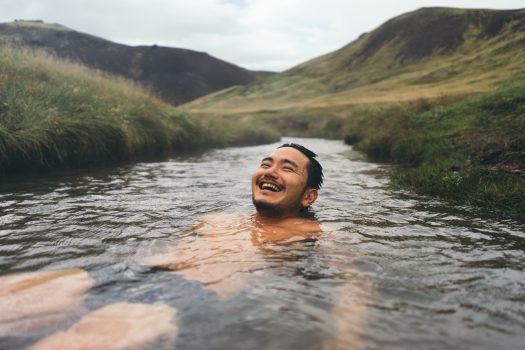 A man soaks in a natural hot spring in Iceland.