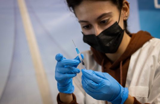 Health worker prepares a Covid-19 vaccine at a temporary Clalit health care center in Jerusalem, September 30, 2021. (photo credit: YONATAN SINDEL/FLASH90)